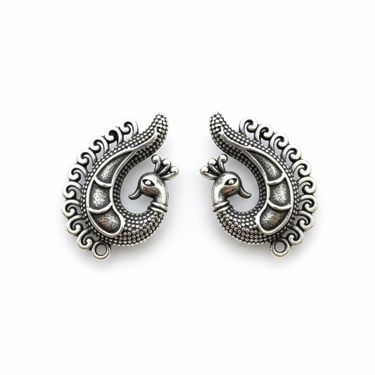Pair of silver peacock-shaped earrings on a white background