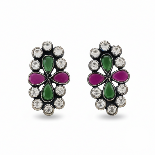 Pair of earrings with green and purple floral designs on a white background