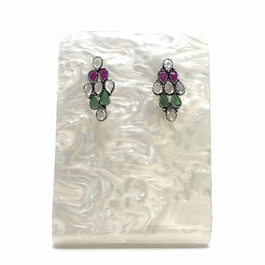 Pair of earrings with gemstones on a white shell background