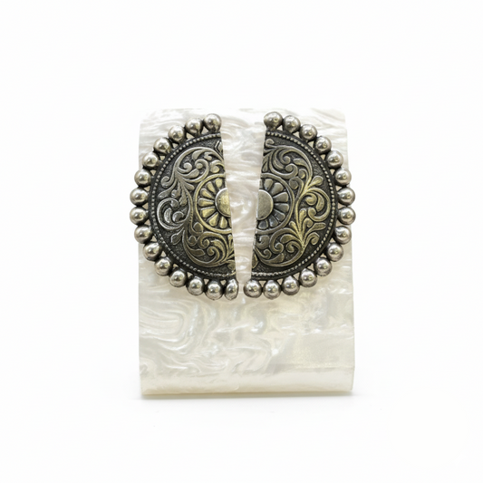 Decorative belt buckle with intricate patterns on a white background