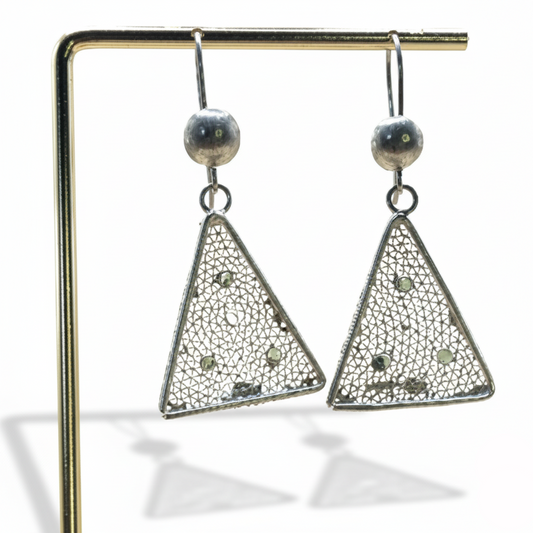 Triangular earrings on a stand with a white background