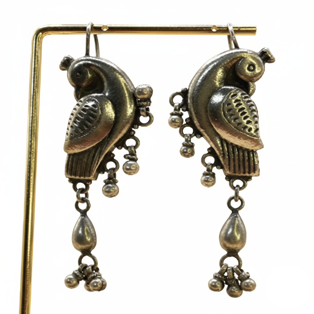 Pair of ornate bird-shaped earrings with dangling elements on a white background