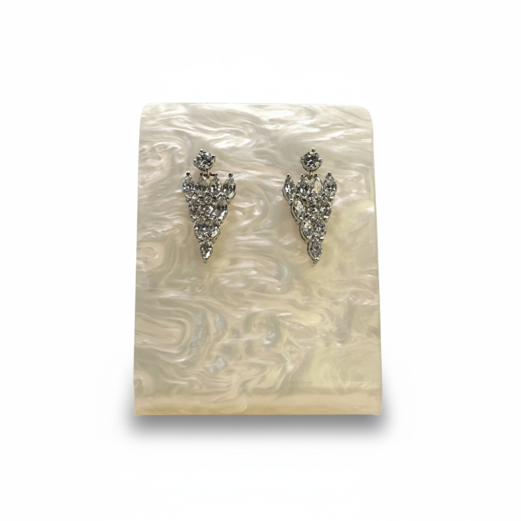 Pair of silver earrings on a decorative stone background