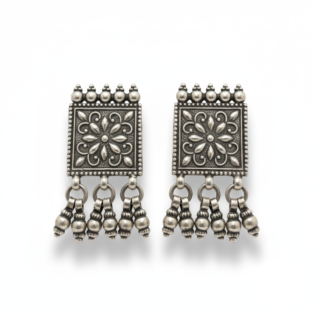 Pair of silver earrings with floral designs and dangling beads on a white background