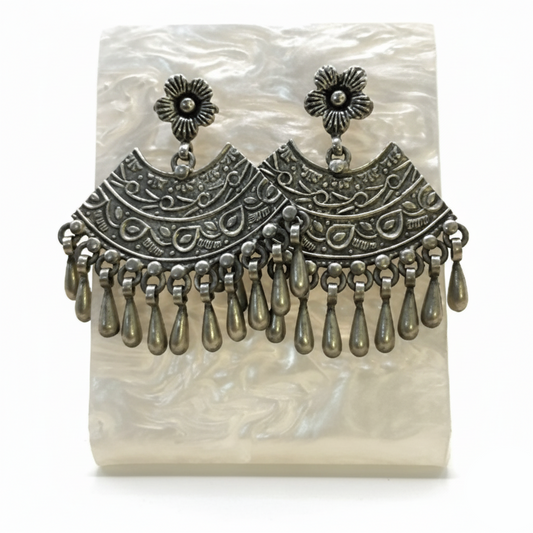 Pair of silver earrings with intricate designs on a white background