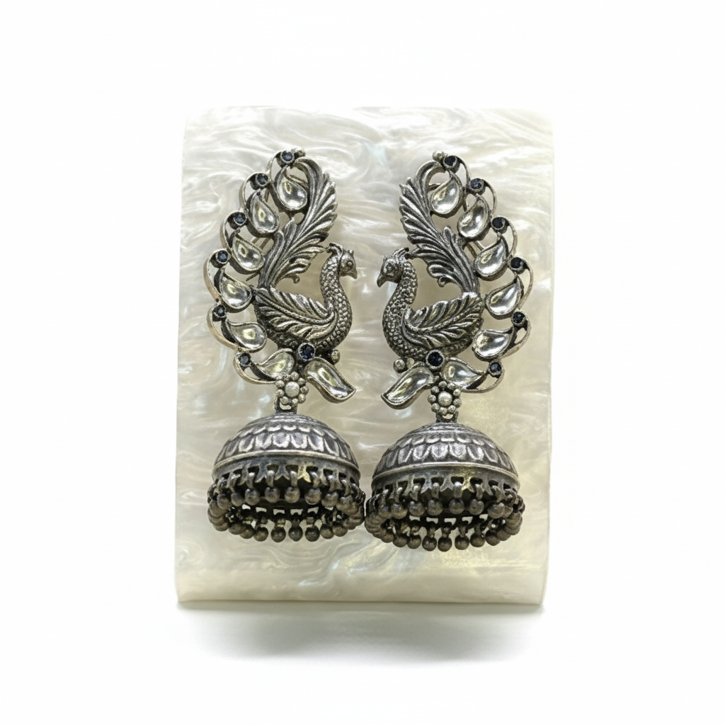 Pair of silver peacock feather earrings on a white background