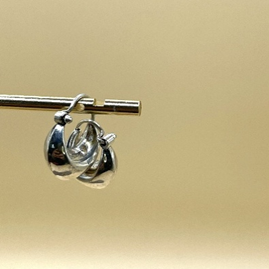 Silver earring on a beige background