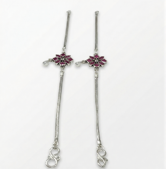 Pair of silver hairpins with floral designs on a white background